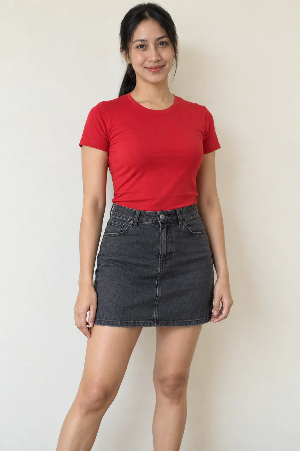 Model standing in a red top and charcoal skirt